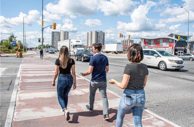 Three pedestrians crossing the street