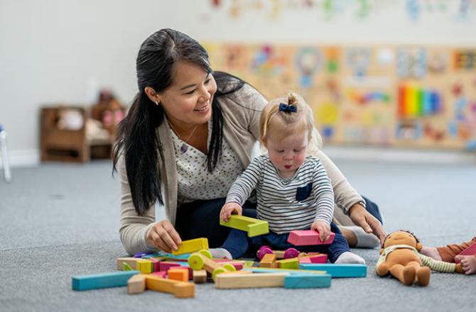 teacher playing with young student on the floor