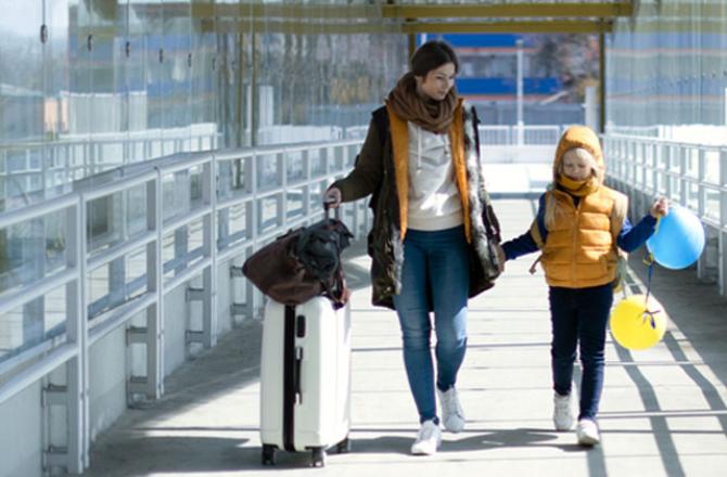 Mother and daughter walking with luggage