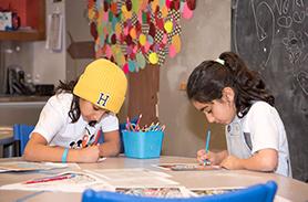 Two children colouring on paper