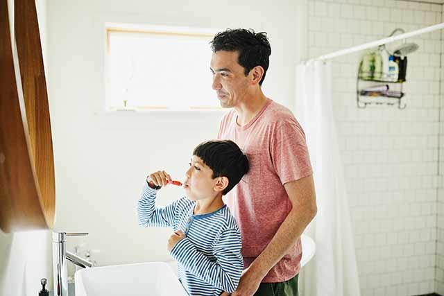 Father and child brushing teeth